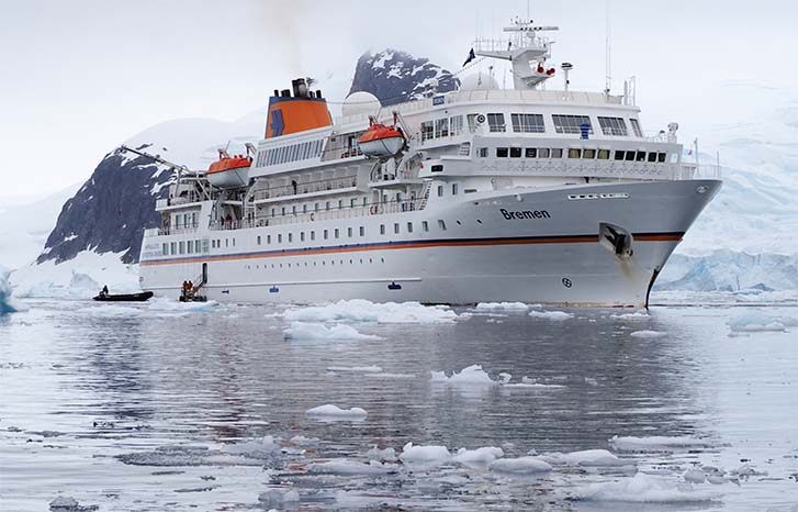 Small expedition cruise ship among sea ice in Antarctica