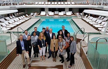 Business group posing on a cruise ship pool deck