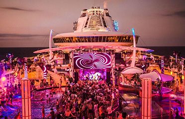 Crowd at a night-time party on a cruise ship deck