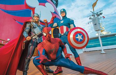 Costumed superhero characters posing on a cruise ship deck